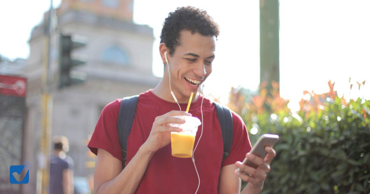 jeune homme écoutant de la musique et buvant un jus d'orange