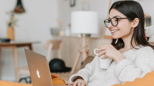 jeune femme prenant son café devant son ordinateur